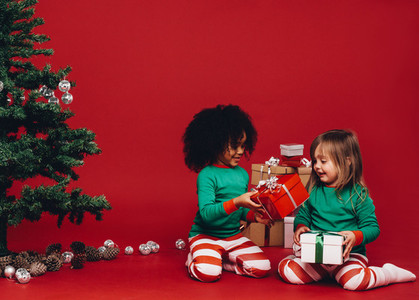 Little girls playing with their christmas gifts boxes