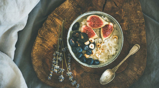 Rice coconut porridge with figs  berries and hazelnuts in bowl