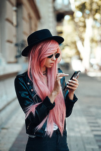 girl with pink hair with a smartphone