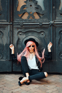 girl with pink hair posing on city street