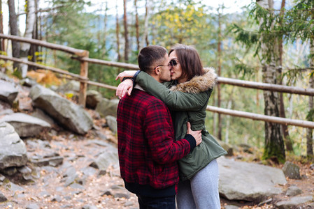 girl and a young man kissing in the woods