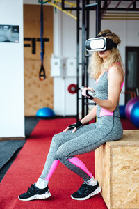 Beautiful girl in the gym with VR headset