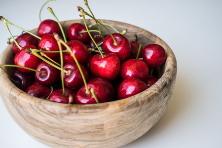 Red cherries in wooden bowl