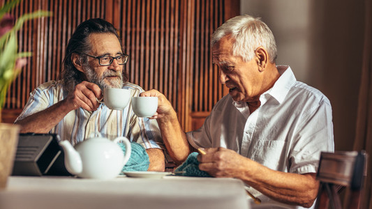 Retired friends having tea while knitting