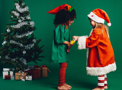 Kids in christmas costumes playing with a toy