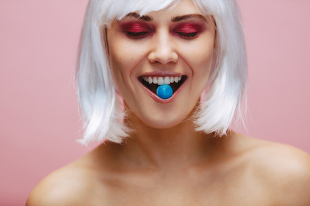 Woman in wig enjoying eating candy