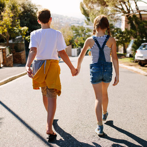 Kids in love walking on street holding their hands