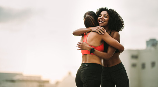 Fitness women hugging each other