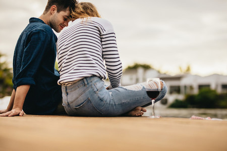 Couple on a romantic date sitting near a lake