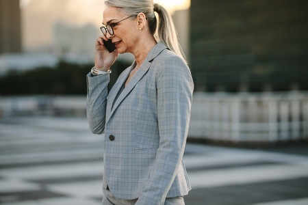 Mature businesswoman on way to home using phone
