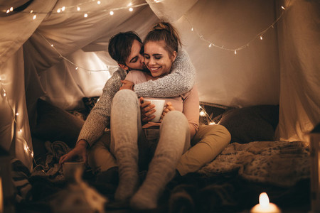 Couple sitting on bed together in romantic mood