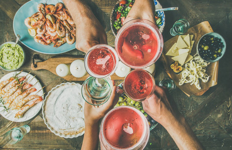 Flat lay of friends hands eating and drinking together  horizontal composition