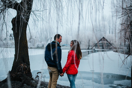 beautiful couple posing near a frozen river