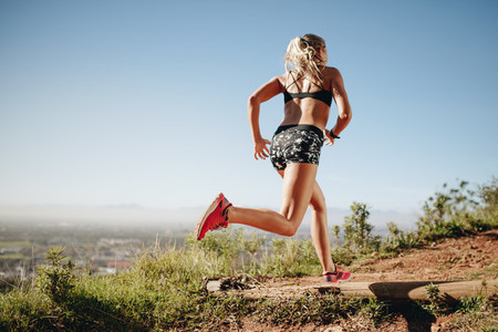 Fitness woman running on a hill