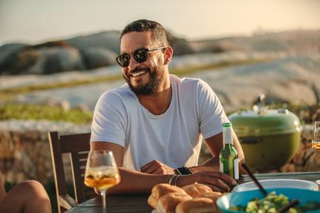 Man sitting outdoors with drinks and snacks