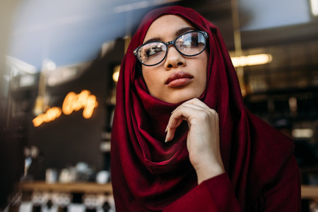 Woman in hijab looking away thinking