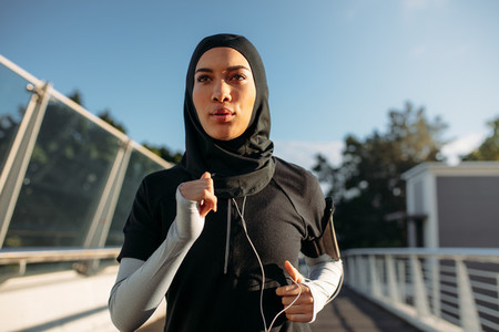 Healthy sporty woman in hijab jogging