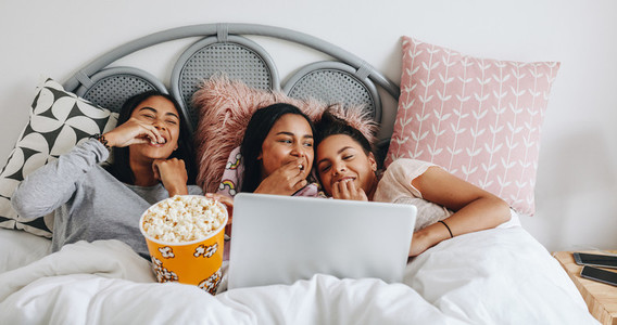 Girls enjoying a movie on laptop during sleepover