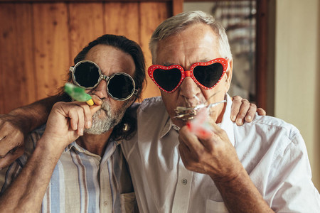 Two old friends with party blowers