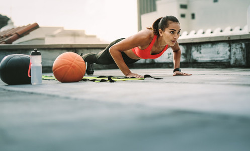 Female athlete doing fitness workout on rooftop