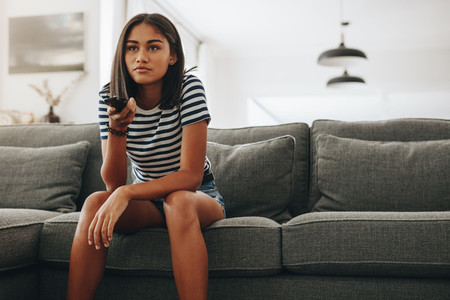 Girl watching television sitting at home