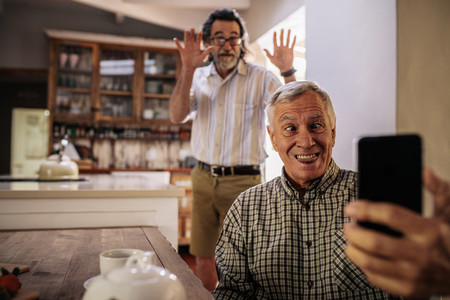 Funny seniors taking selfie at home