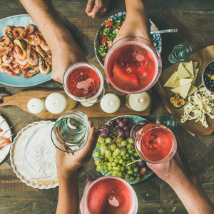 Flat lay of friends hands eating and drinking together square crop