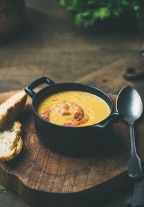 Corn creamy soup with shrimps served in pot  copy space