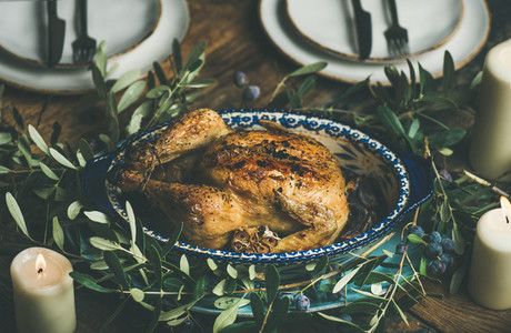 Whole roasted chicken with garlic decorated with olive tree branch