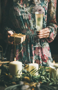 Woman holding glass of champaigne and gift box during Christmas