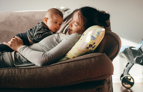 Woman lying on couch with her baby