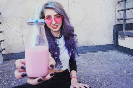 Happy beautiful teen with pink sunglasses cheers and enjoys a pi
