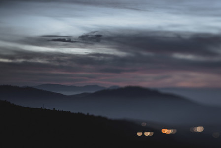 Blurry bokeh lights in dusk mountains