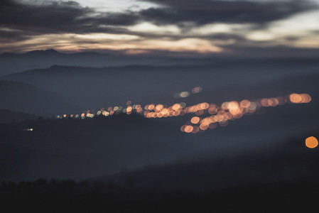 Blurry bokeh lights in dusk mountains