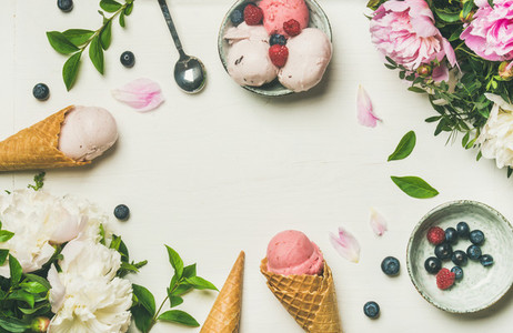 Flatlay of ice cream scoops and peonies over white background