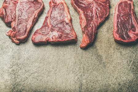 Flat lay of fresh raw beef meat steaks  selective focus