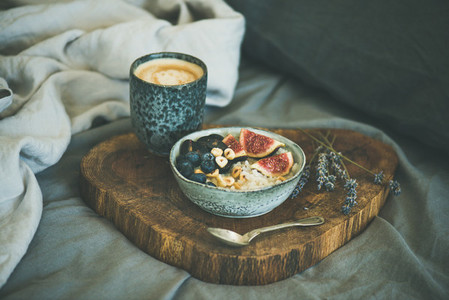 Rice coconut porridge and cup of coffee in bed