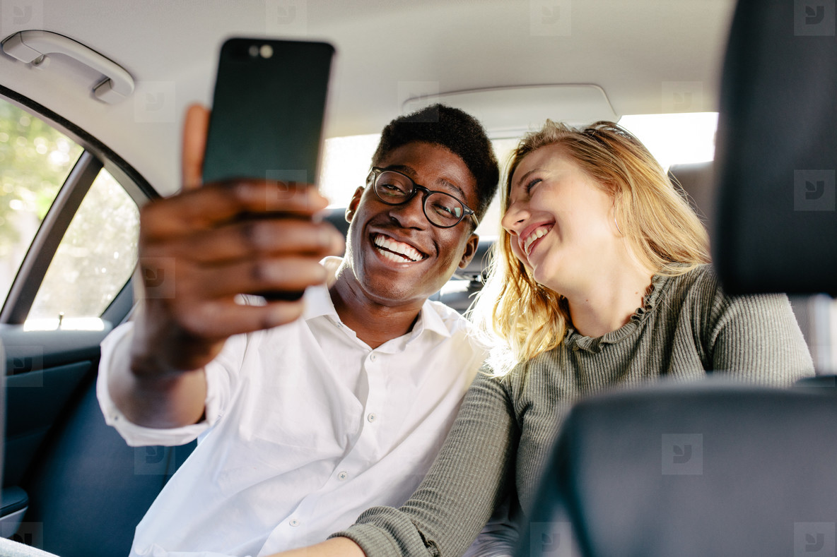 Couple traveling by a car taking selfie