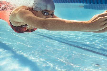 Female swimmer gliding in pool