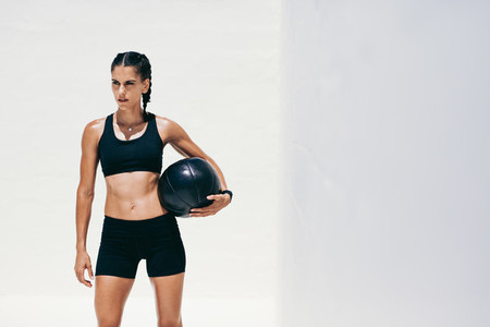 Portrait of a fitness woman standing holding a medicine ball