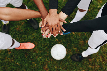 Close up of hands of players standing together in a huddle