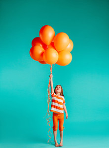 Cute girl holding orange balloons