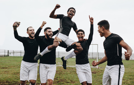 Footballers celebrating success on field