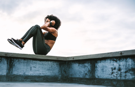 Woman athlete doing workout on rooftop