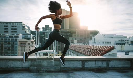 Fitness woman running on rooftop
