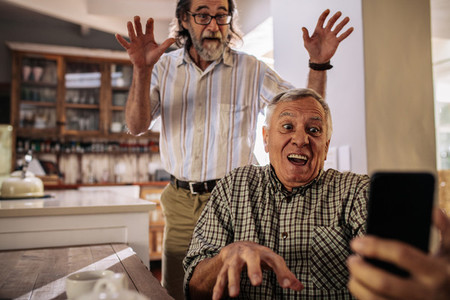 Retired men making funny faces while taking selfie