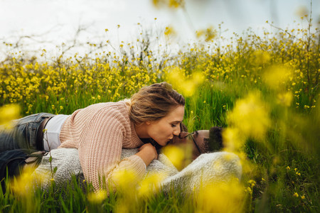 Romantic couple kissing on flowering meadow
