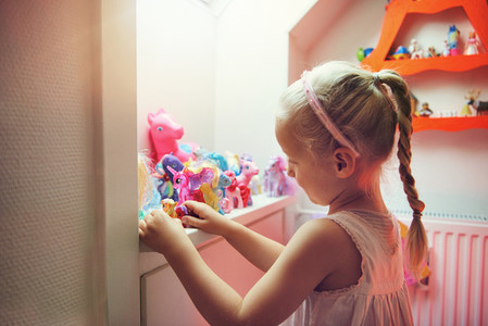 Girl playing with figurines in her room