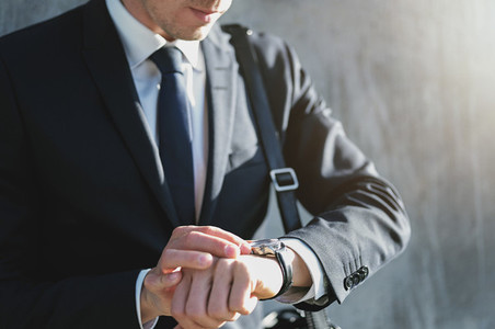 A businessman setting time on the watch