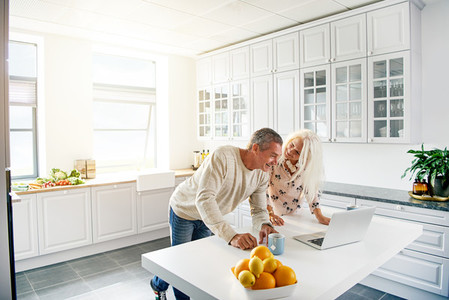 Kitchen scene with couple looking at computer